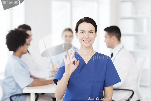 Image of happy doctor over group of medics at hospital