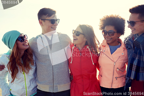 Image of happy teenage friends in shades talking on street