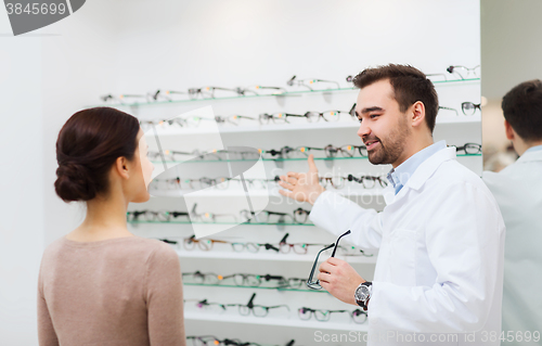 Image of woman and optician showing glasses at optics store