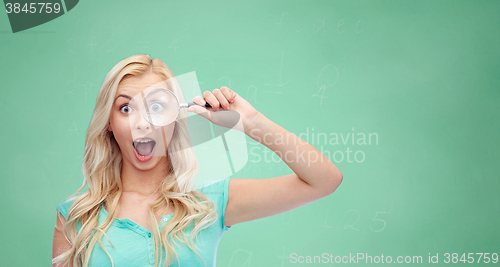 Image of happy young woman with magnifying glass