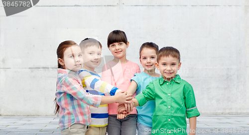 Image of happy little children holding hands on street