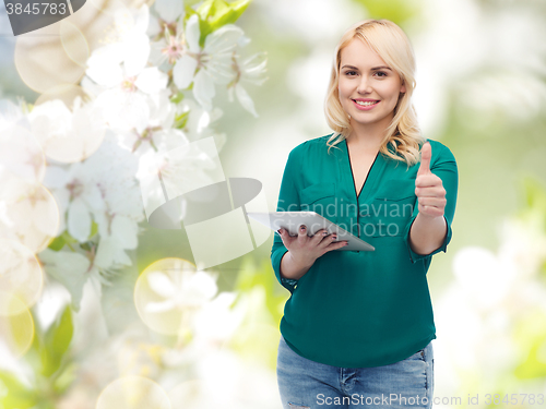 Image of smiling woman with tablet pc showing thumbs up