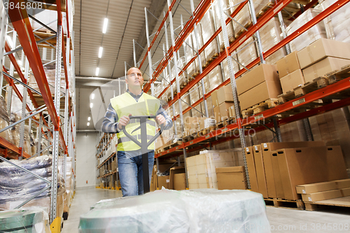 Image of man carrying loader with goods at warehouse