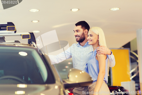 Image of happy couple buying car in auto show or salon