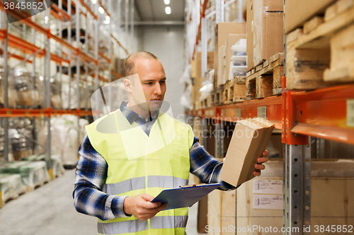 Image of man with clipboard in safety vest at warehouse