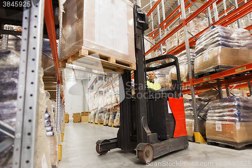 Image of man on forklift loading cargo at warehouse