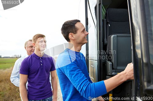 Image of group of happy male passengers boarding travel bus