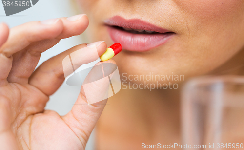 Image of close up of woman taking medicine in pill