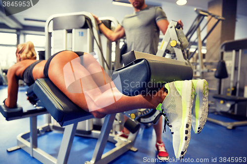 Image of man and woman flexing muscles on gym machine