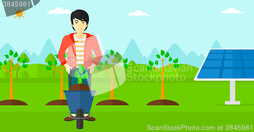 Image of Man with plant and wheelbarrow.