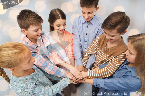 Image of happy children with hands on top over lights