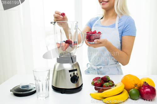 Image of close up of woman with blender making fruit shake