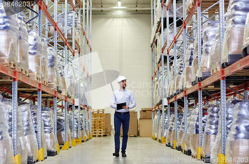 Image of happy businessman with clipboard at warehouse