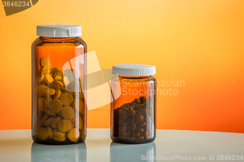 Image of Two glasses with pills on a table