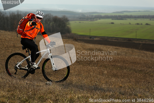Image of Man cyclist with backpack riding the bicycle