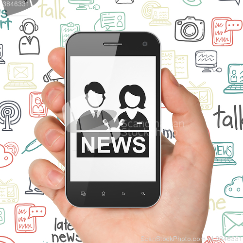 Image of News concept: Hand Holding Smartphone with Anchorman on display