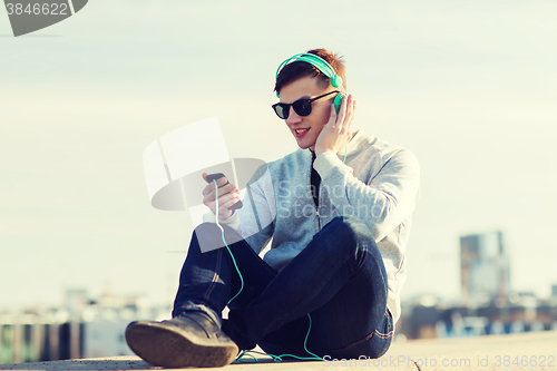 Image of happy young man in headphones with smartphone