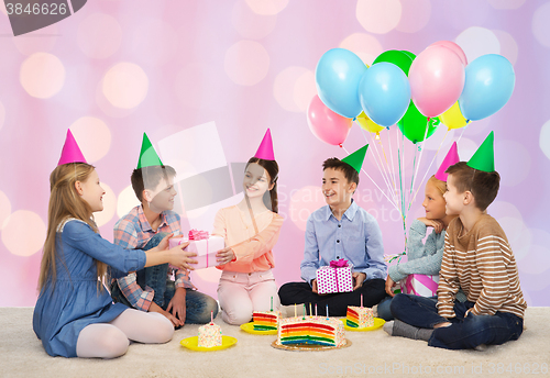 Image of happy children giving presents at birthday party