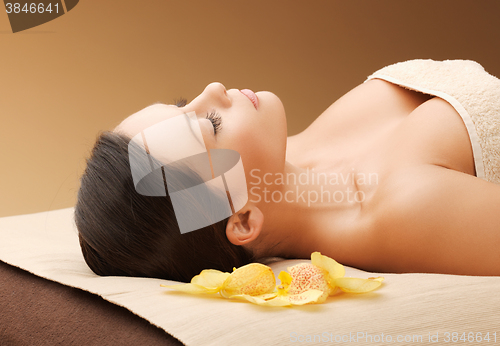 Image of woman in spa salon lying on the massage desk