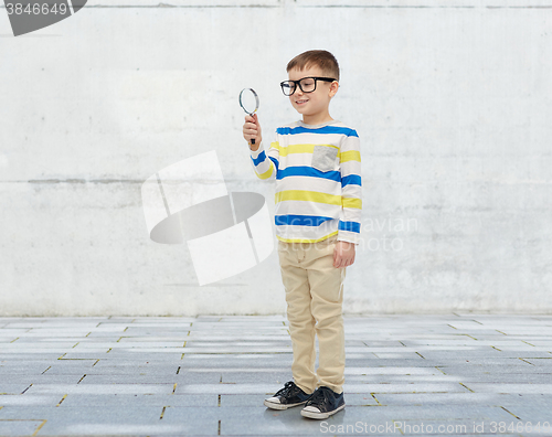 Image of little boy in eyeglasses with magnifying glass