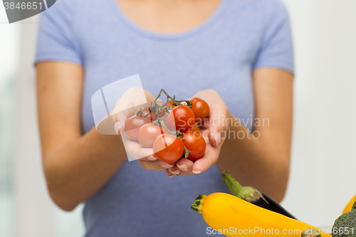Image of close up of woman holding cherry tomatoes in hands