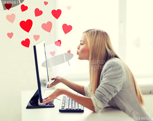 Image of woman sending kisses with computer monitor