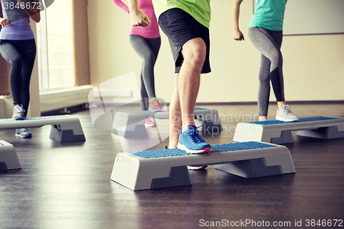 Image of group of people flexing legs on step platforms