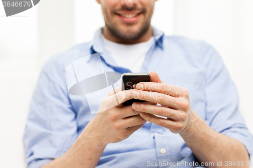 Image of close up of man with smartphone at home