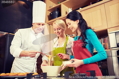 Image of happy women and chef cook baking in kitchen