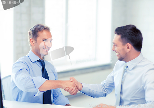 Image of businessmen shaking hands in office