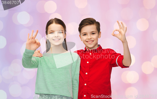 Image of happy boy and girl showing ok hand sign