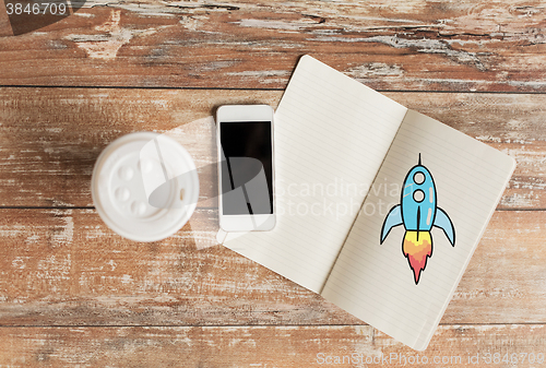 Image of close up of notebook, coffee cup and smartphone