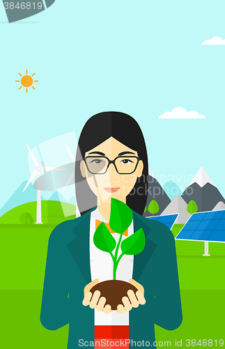 Image of Woman holding plant.