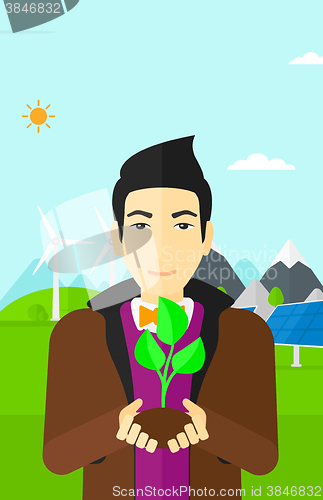 Image of Man holding plant.