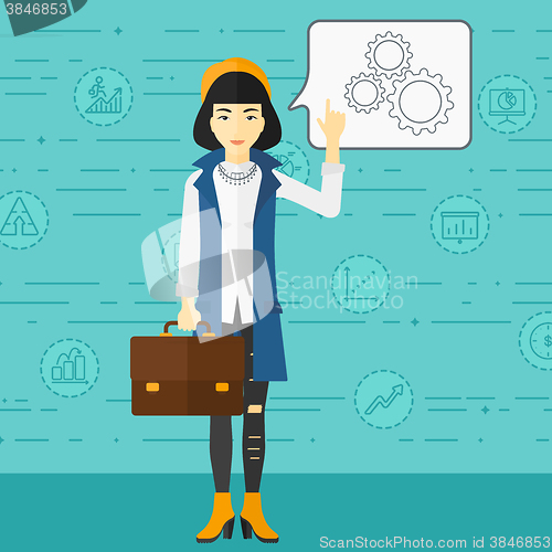 Image of Business woman pointing at cogwheels.