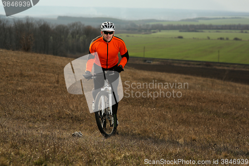 Image of Man cyclist with backpack riding the bicycle