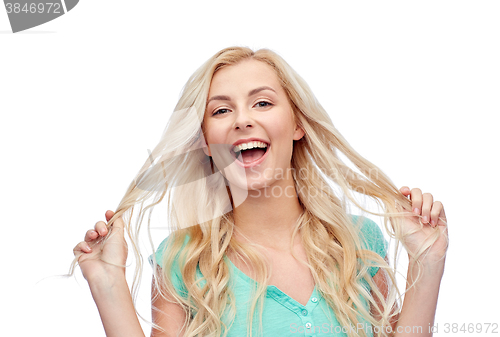 Image of smiling young woman holding her strand of hair