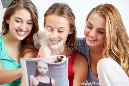 Image of friends or teen girls reading magazine at home