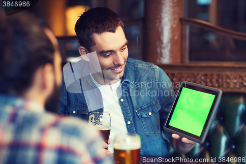 Image of male friends with tablet pc drinking beer at bar