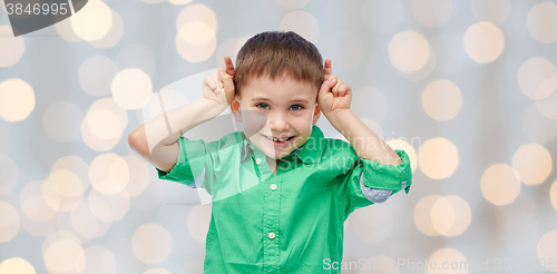 Image of happy little boy having fun and making horns