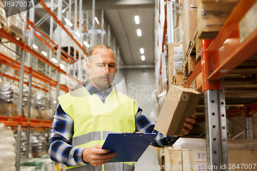 Image of man with clipboard in safety vest at warehouse