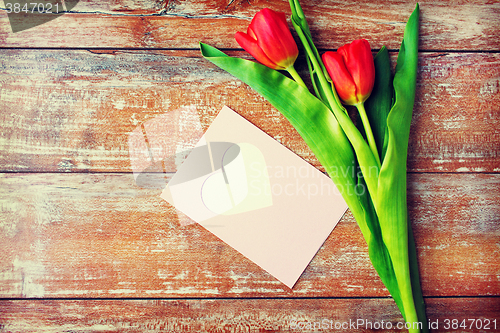 Image of close up of tulips and greeting card with heart