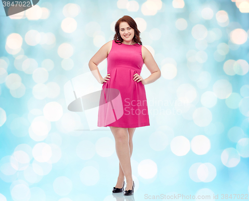 Image of happy young plus size woman posing in pink dress