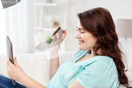 Image of plus size woman with tablet pc and credit card