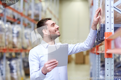 Image of happy businessman with tablet pc at warehouse