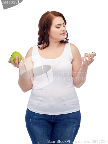 Image of young plus size woman choosing apple or cookie