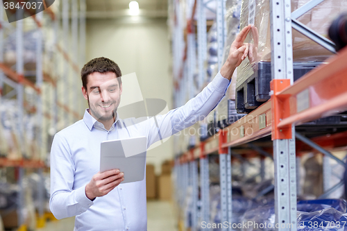 Image of happy businessman with tablet pc at warehouse