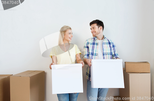 Image of smiling couple with big boxes moving to new home