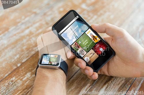 Image of close up of hands with smart phone and watch