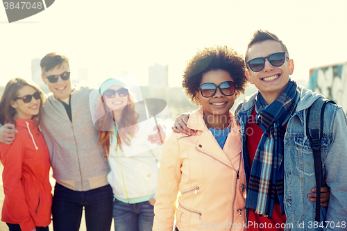 Image of happy teenage friends in shades talking on street